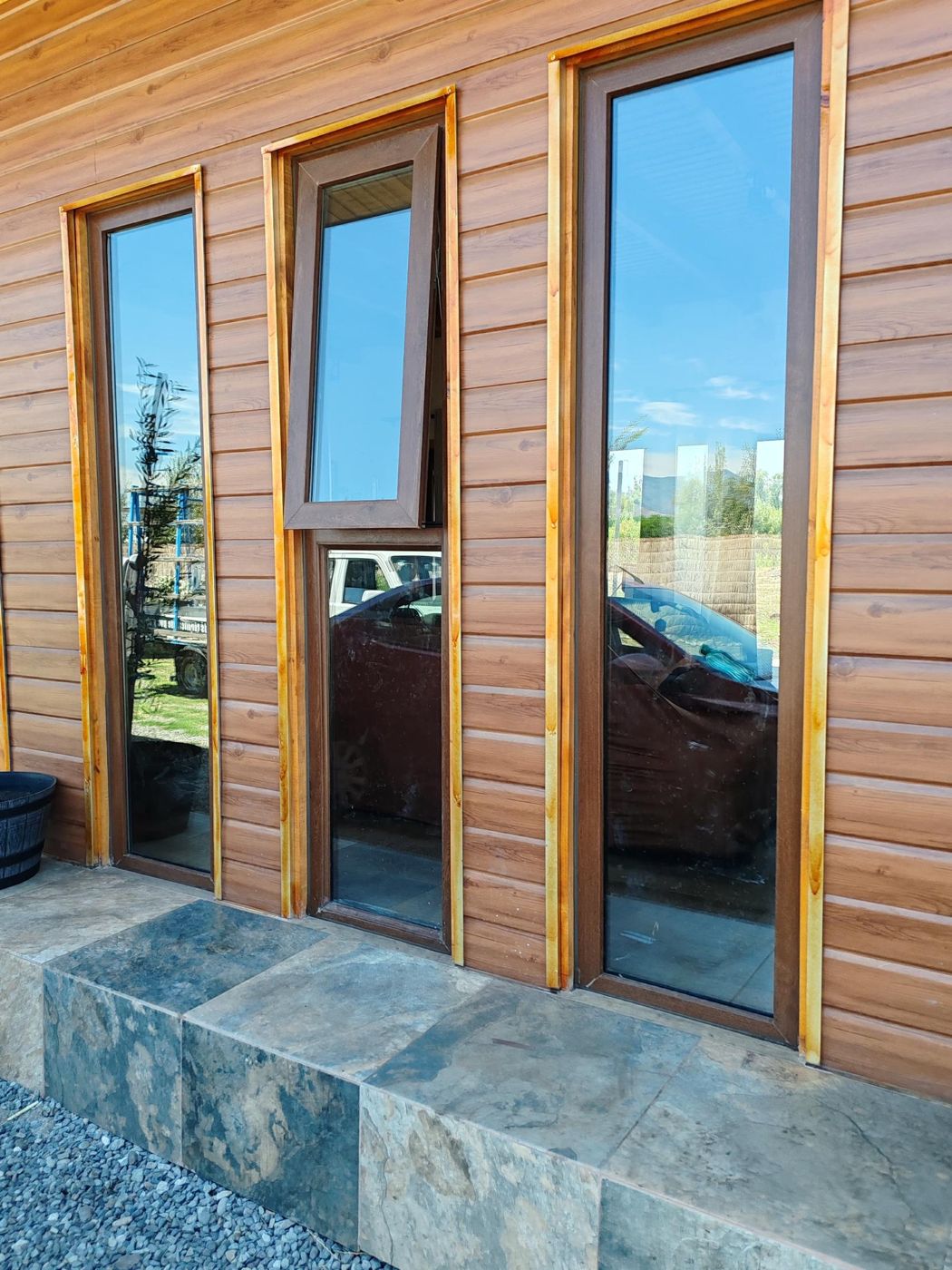 Ventanas altas de PVC nogal en casa de madera